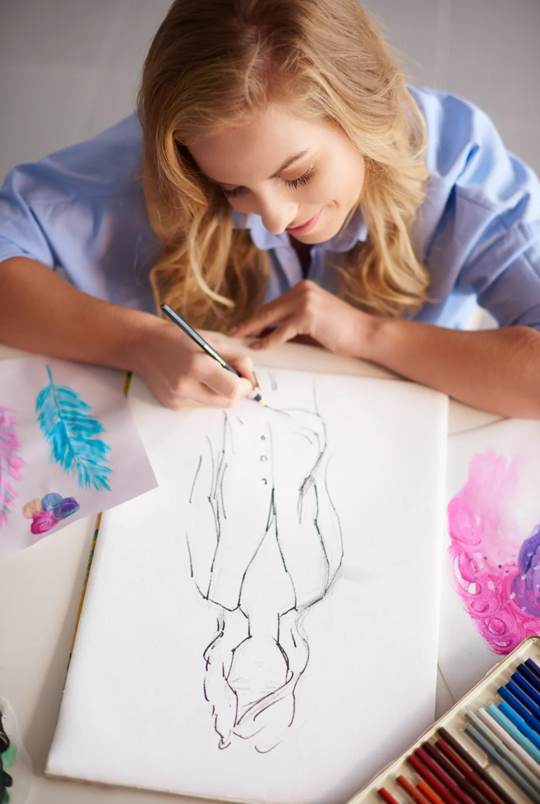 Young artist drawing a human figure in pencil on paper
