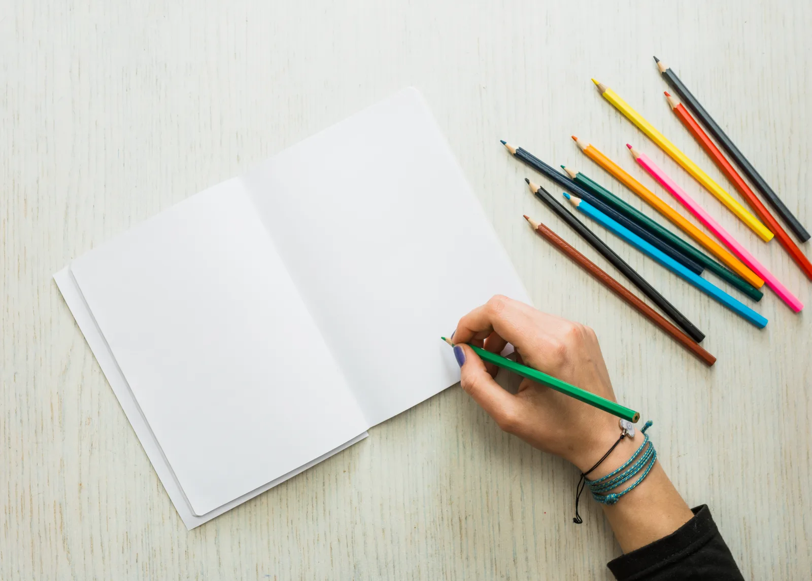 Hand drawing with a colour pencil in an open sketchbook